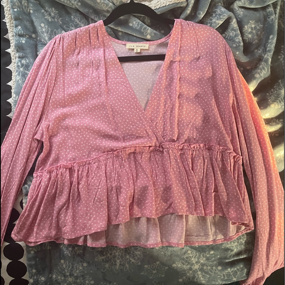 This is a pink crop top with white flowers scattered throughout the top.